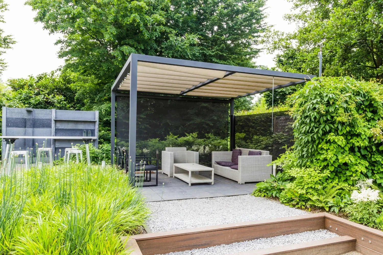 Modern louvered-roof pergola over a paved seating area with wicker outdoor furniture