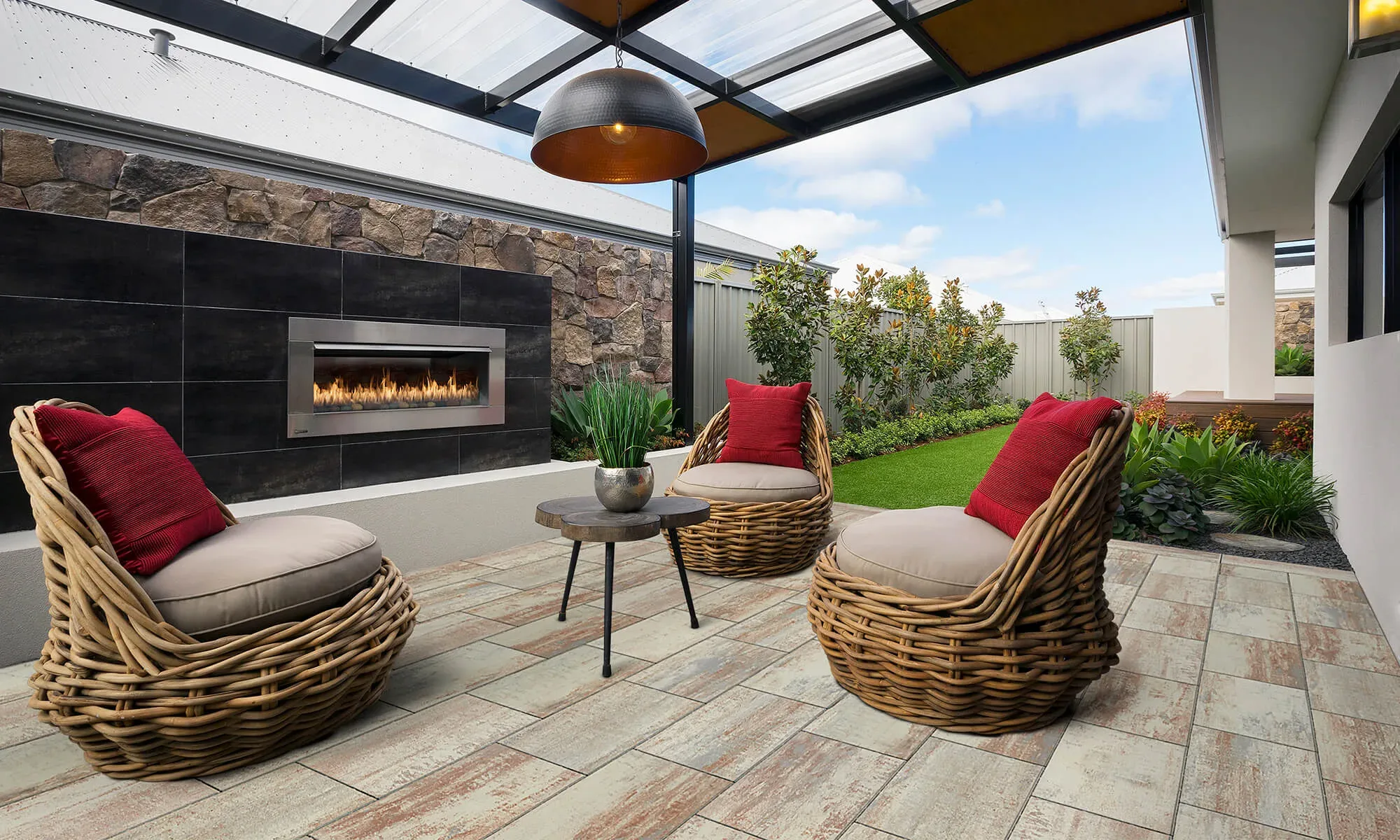 Covered patio under a pergola roof with a stone-clad wall and built-in linear fire feature
